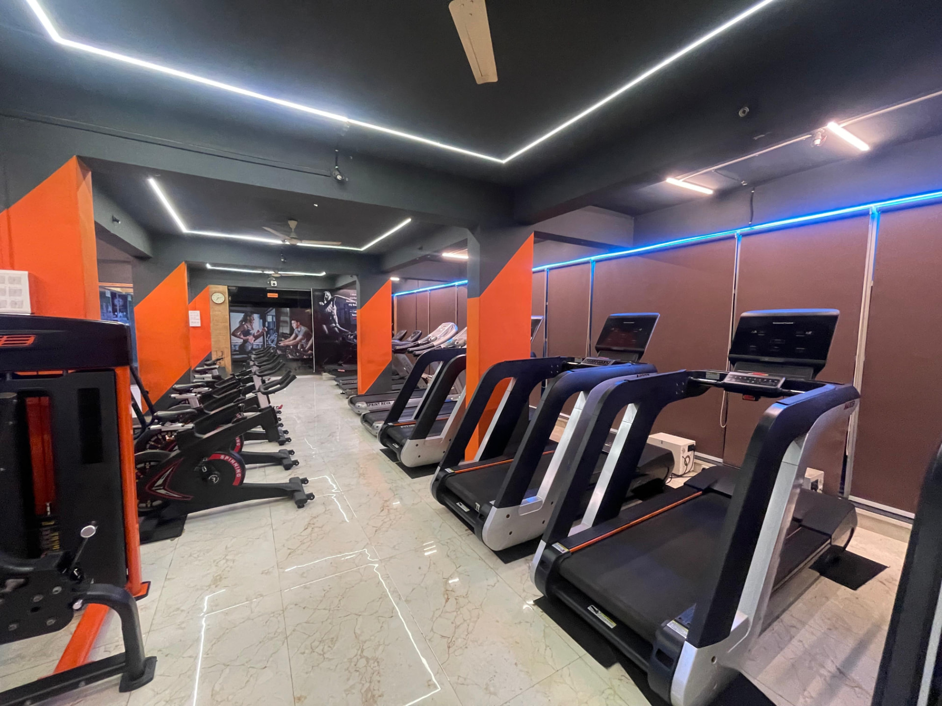 Treadmills and spin bikes lined up in the cardio hall at SK Fitness Gym, Kharadi, Pune